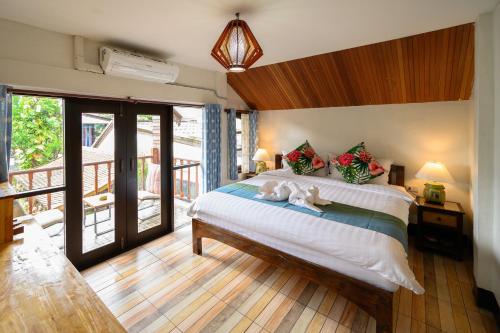 ein Schlafzimmer mit einem Bett mit zwei ausgestopften Tieren darauf in der Unterkunft Hetai Boutique House in Chiang Mai
