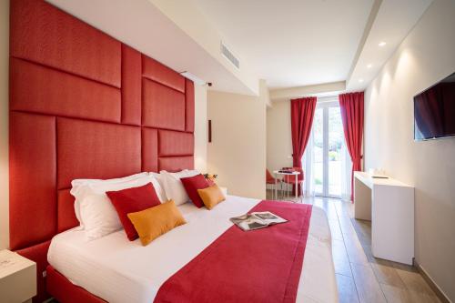 a bedroom with a large bed with a red headboard at Hotel Villa Garuti in Padenghe sul Garda
