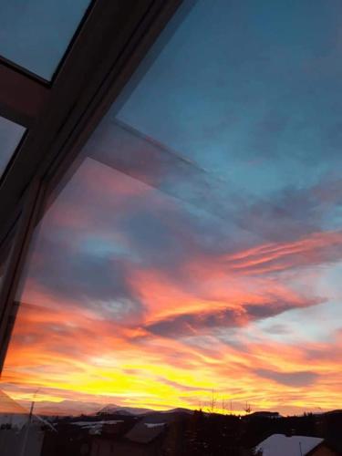 a view of a sunset seen through a window at Pensiunea Romantic Belvedere Paltinis in Păltiniş