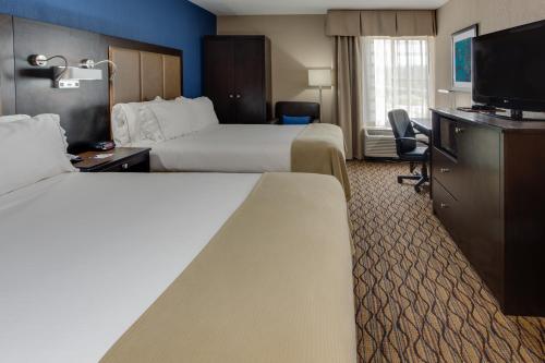 a hotel room with two beds and a flat screen tv at Holiday Inn Express Hunt Valley by IHG in Hunt Valley