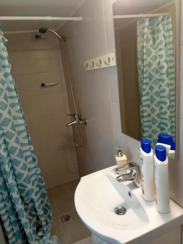a bathroom with a sink and a mirror and a shower at Cozy spot apt next to metro station . in Athens