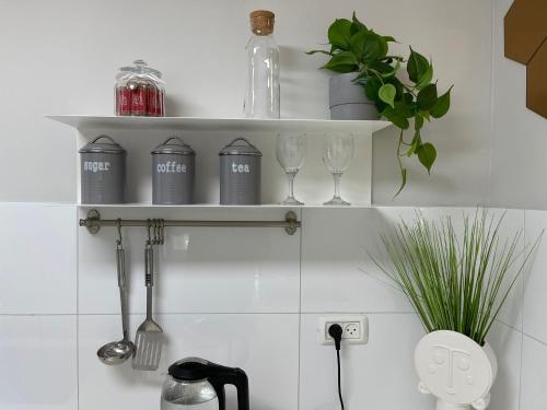 a kitchen shelf with wine glasses and utensils at Carmel Beach Luxury Apartment in Haifa