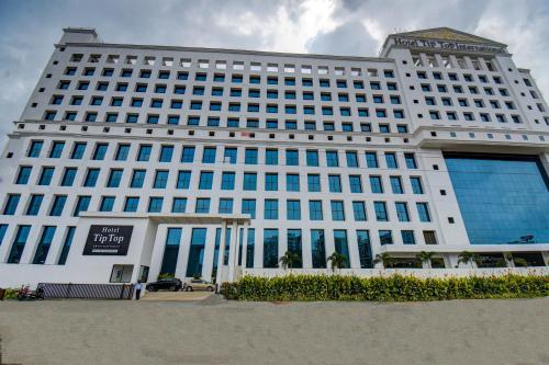 a large white building with blue windows at Hotel Tip Top International Pune in Pune