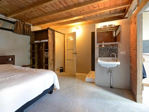 um quarto com uma cama e um lavatório em Norgerbrink em Norg