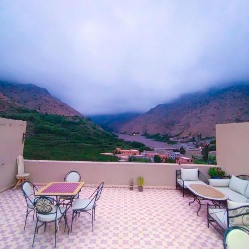 a balcony with tables and chairs and a view of a mountain at Atlas Chalet Armed in Imlil