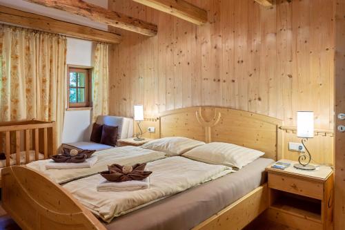 Cama grande en habitación con paredes de madera en Apartment Birke- Fiechterhof, en Sarentino