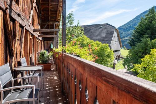 a balcony with chairs and flowers on a building at Apartment Birke- Fiechterhof in Sarntal