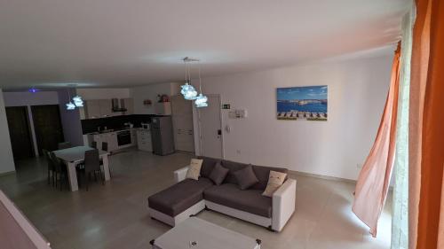 a living room with a couch and a kitchen at Paradise in Għajnsielem