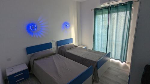 een slaapkamer met 2 bedden en blauwe decoraties aan de muur bij Paradise in Għajnsielem