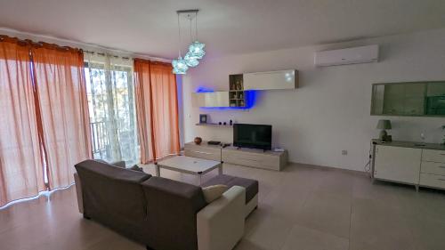 een woonkamer met een bank en een tv bij Paradise in Għajnsielem