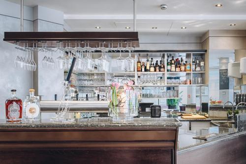 a bar with glasses on a counter in a restaurant at Hotel Moosburger Hof in Pfaffenhofen an der Ilm