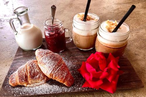 a wooden cutting board with bread and jars of food at A Casa Di Ita in Villorba