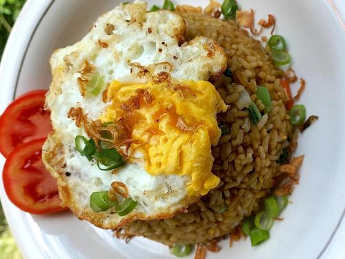 a plate of food with a fried egg and rice at Toraja Homestay & Coffee Bunna in Rantepao
