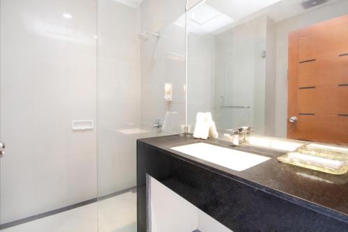 uma casa de banho com um lavatório e um chuveiro em Hotel Bisanta Bidakara Tunjungan em Surabaya