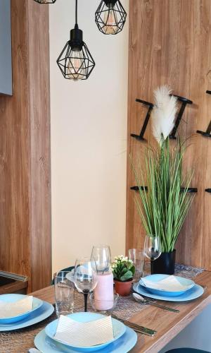 a dining room table with blue and white plates and glasses at Adoro Titova Vila in Zlatibor