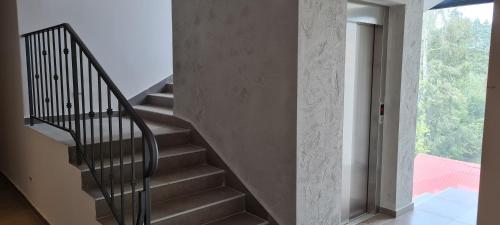 a spiral staircase in a house with a large window at Adoro Titova Vila in Zlatibor