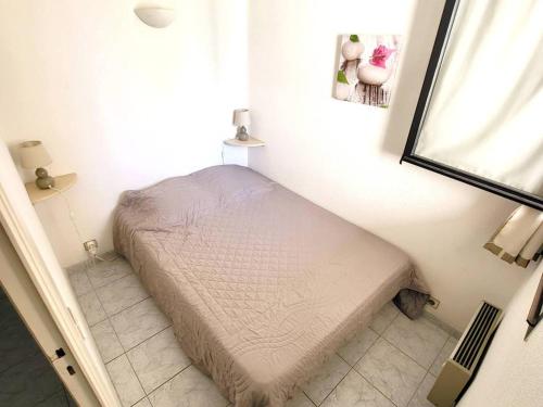 - un petit lit dans un coin de chambre dans l'établissement T2 avec Parking, Piscine, Tennis - 400m Plages et Commerces - FR-1-316-157, à Six-Fours-les-Plages