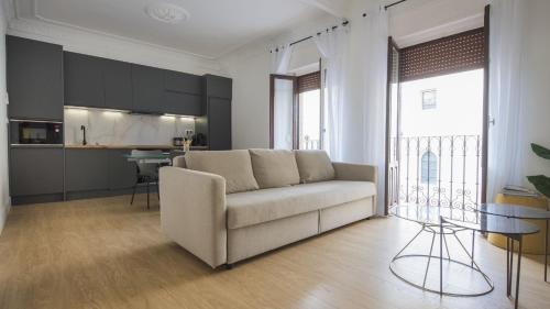 sala de estar con sofá y cocina en Apartamentos Boutique Puerta de Reyes, en Toledo