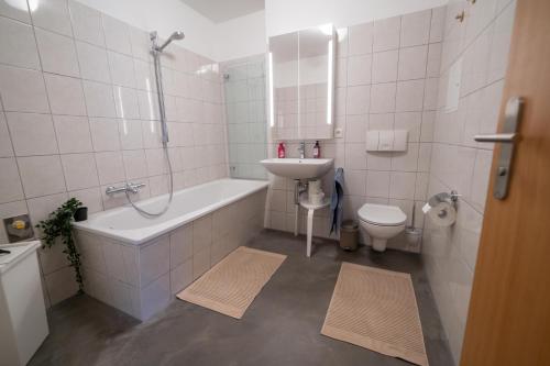 a bathroom with a sink and a tub and a toilet at FullHouse - Zwickau - L12 - 2 Single Beds - Nespresso - SmartTV in Zwickau
