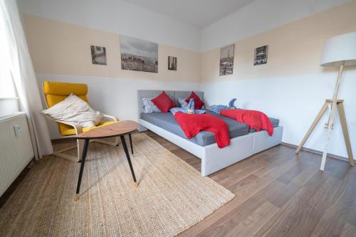 een kamer met een bed met rode kussens en een tafel bij FULL HOUSE Studios - Apartment French Touch in Zwickau