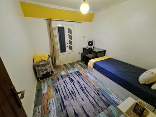 a small room with a bed and a desk and a table at Sunny modern apartment with good internet, near from city center of Alexandria in Alexandria