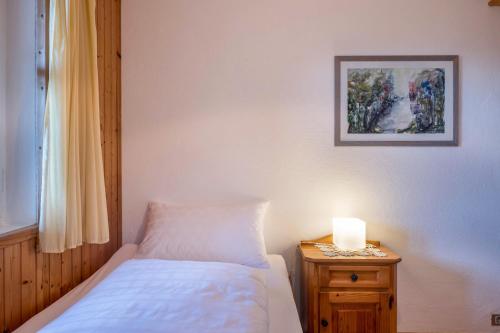 a bedroom with a bed and a lamp on a night stand at Ferienhaus Fingerhut in Eggen