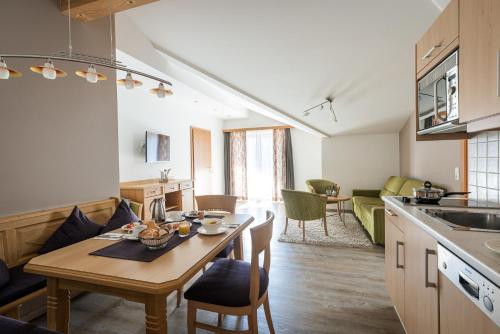 a kitchen and living room with a table in a room at Hotel Sonnegg in Saalbach Hinterglemm