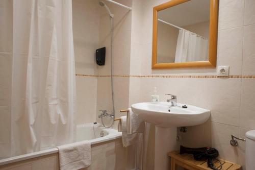 a bathroom with a sink and a shower with a mirror at Apartament Bisaura de Ter in Sant Quirze de Besora