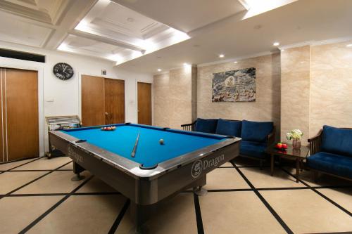 a pool table in a living room with blue furniture at Hanoi Backpackers Hostel & Rooftop bar in Hanoi