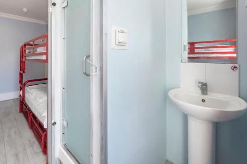 a bathroom with a sink and a mirror at Astor Victoria Hostel in London