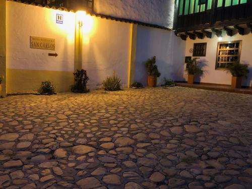 a cobblestone street in front of a building at night at Hotel Hospederia San Carlos Villa De Leyva in Villa de Leyva