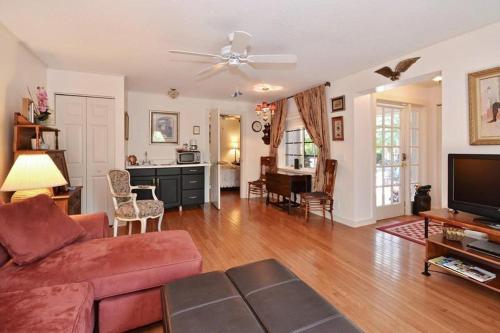 a living room with a couch and a flat screen tv at Sabal Palm House Bed and Breakfast in Lake Worth