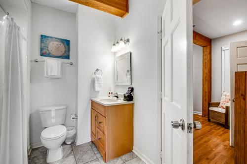 a white bathroom with a toilet and a sink at Historic City Market - Loft Off Broughton Too in Savannah