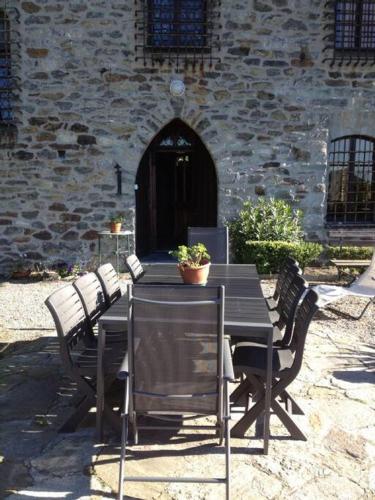 a black table and chairs with a potted plant on it at Romantic Italian Castle at the foot of the Alps in Settimo Vittone