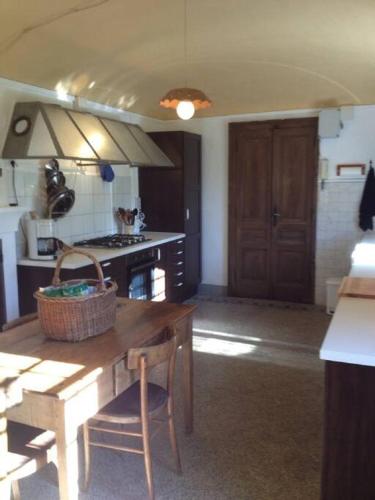 a kitchen with a wooden table with a basket on it at Romantic Italian Castle at the foot of the Alps in Settimo Vittone