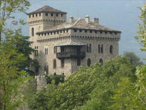a large building on top of a hill with trees at Romantic Italian Castle at the foot of the Alps in Settimo Vittone