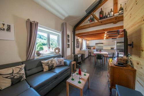 a living room with a blue couch and a kitchen at Le Valtin Gite au calme in Le Valtin