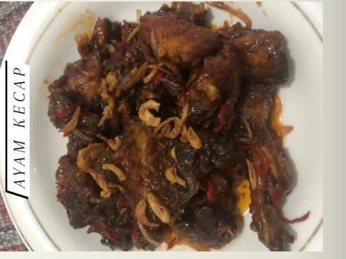 a white plate of food with meat and onions at Toraja Homestay & Coffee Bunna in Rantepao