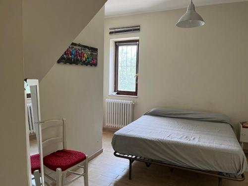 1 dormitorio pequeño con 1 cama y 1 silla en La casa di Silvia, en Cantalupo in Sabina
