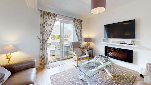 a living room with a couch and a fireplace at Min Y Don in Abersoch
