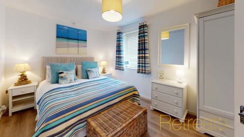 a bedroom with a bed and two night stands and a window at Min Y Don in Abersoch