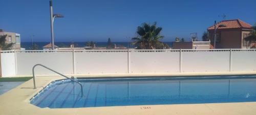 - une piscine à côté d'une clôture blanche dans l'établissement Alojamiento roquetas de mar, à Roquetas de Mar