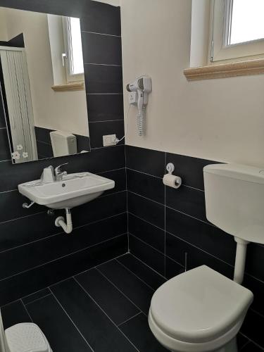 a black and white bathroom with a toilet and a sink at B&B Roseal in Brusciano