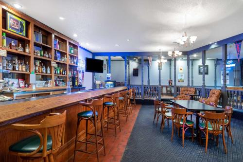 un bar in un ristorante con tavoli e sedie di Days Inn & Suites by Wyndham Clovis a Clovis