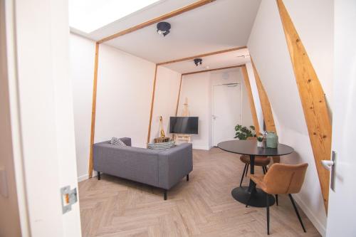 - un salon avec un canapé et une table dans l'établissement Appartement in binnenstad/centrum van Leeuwarden, à Leeuwarden