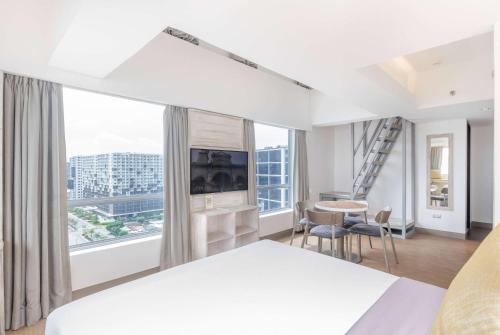 a hotel room with a large bed and a large window at TRYP by Wyndham Mall of Asia Manila in Manila