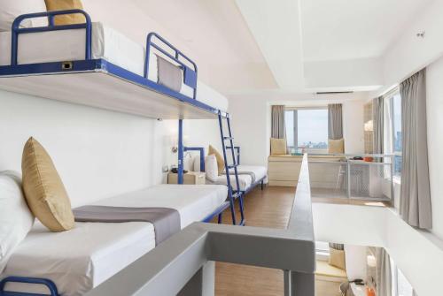 a room with three bunk beds and a hallway at TRYP by Wyndham Mall of Asia Manila in Manila