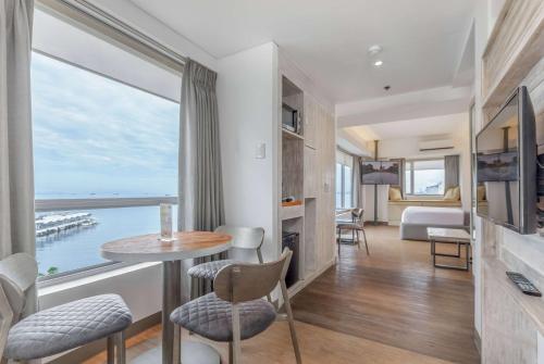 a living room with a table and chairs and a large window at TRYP by Wyndham Mall of Asia Manila in Manila