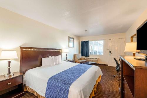 a hotel room with a large bed and a desk at Rodeway Inn Phoenix North I-17 in Phoenix