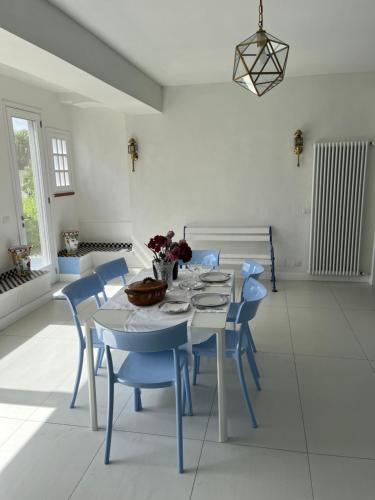 a dining room with a table and blue chairs at Casa Azzurra in Messina